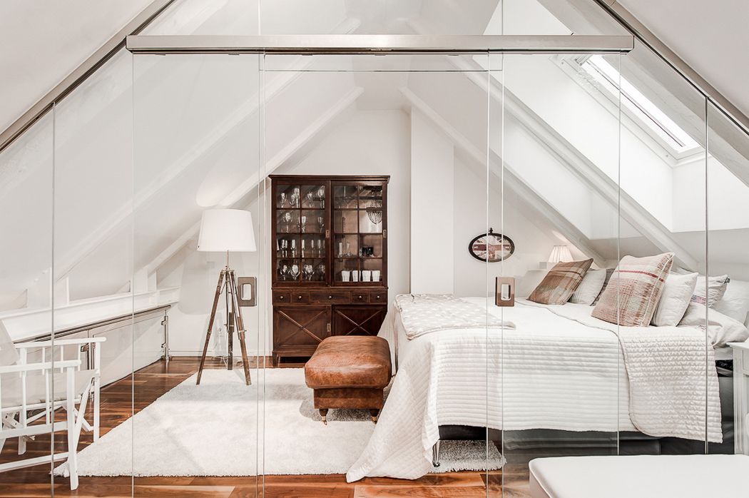 Üvegpadló a belső két szint között, fehér falak és meleg fa padló - egy rendkívül látványos tetőtéri lakás