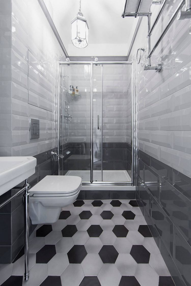 Hatszögletű fekete-fehér padlóburkolat, alul szürke, felül fehér klasszikus, fózolt szélű metro csempe falburkolat, zuhanyfülke