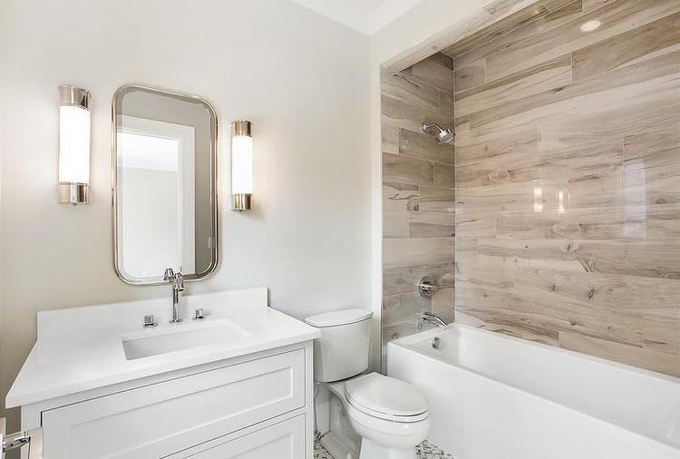 Fehér fürdőszobában a kád környékét szépen kiemeli a fahatású burkolat