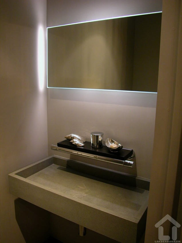 Minimalista design világító keretbe foglalt tükörrel és szögletes kő mosdóval, látványos csapteleppel