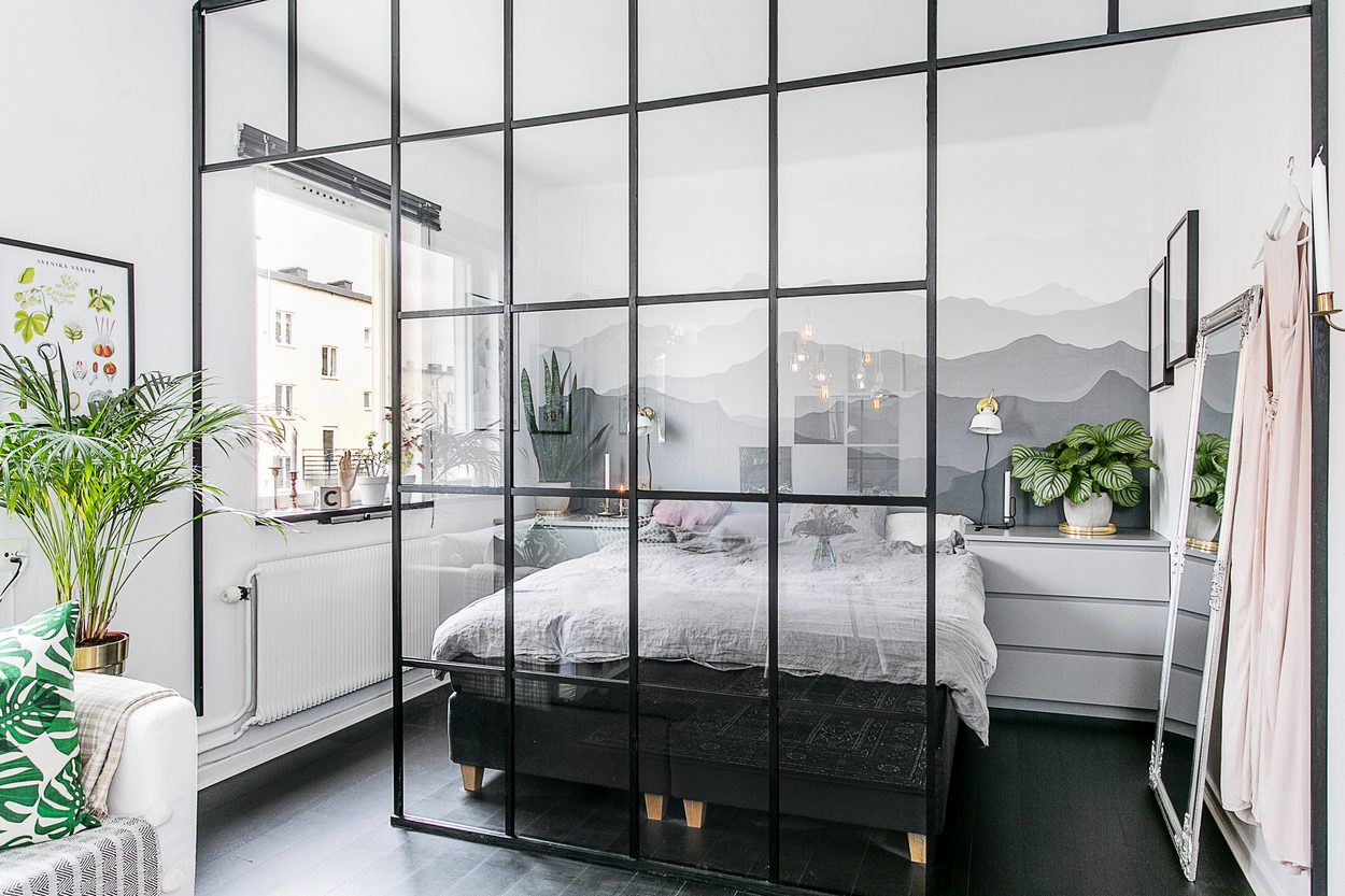 Üvegfallal elválasztott háló, nőies és kontrasztos elemek, fekete padló, tégla egy 35m2-es kis lakásban