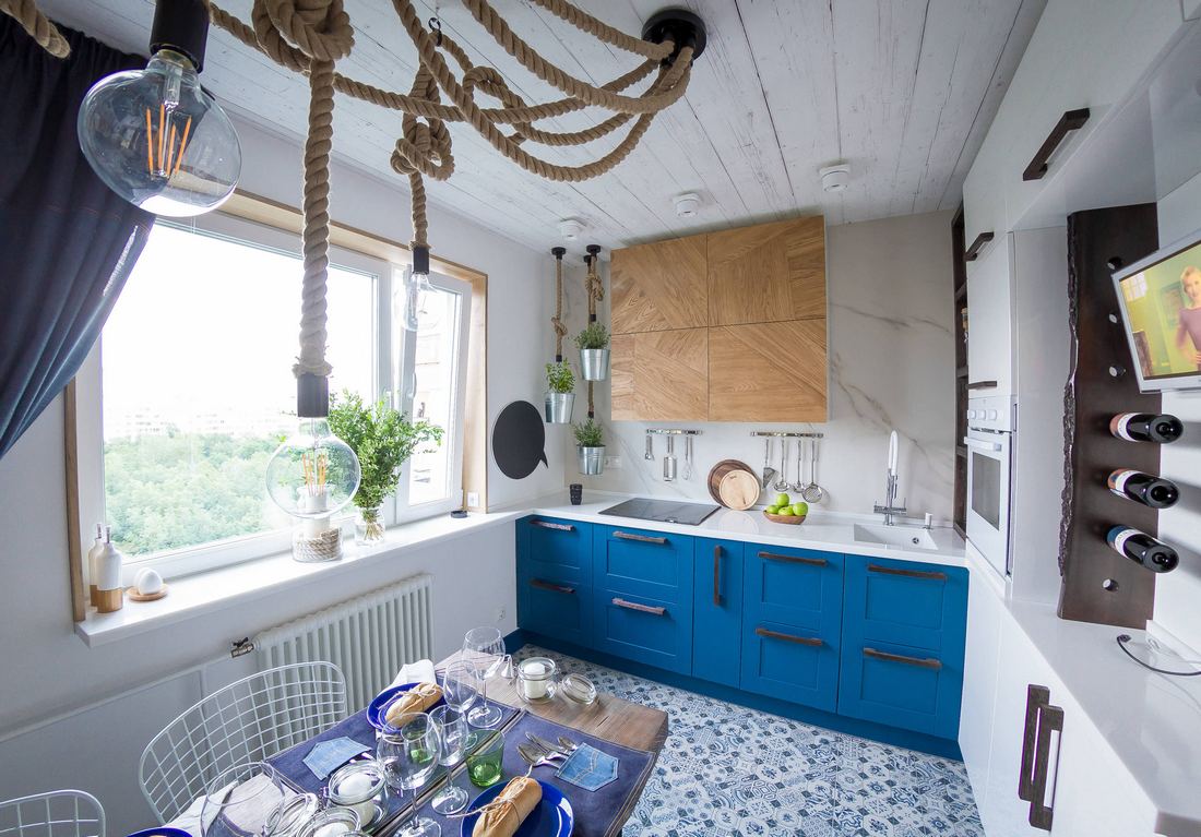 Panellakás nagyobb helyiségéből kialakított egyedi hangulatú konyha kék, fehér fa kombinációval