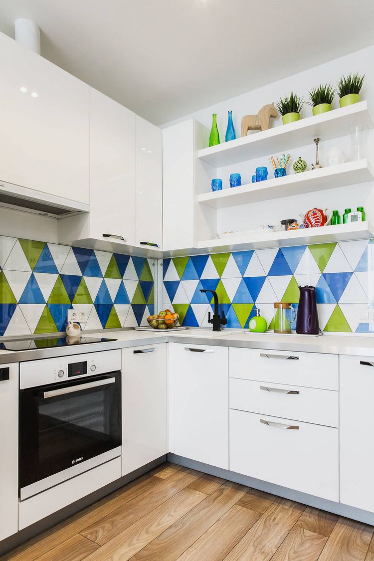 Fehér konyha, fa hatású kerámia padló, élénk, mintás zöld-fehér-kék konyha hátfal