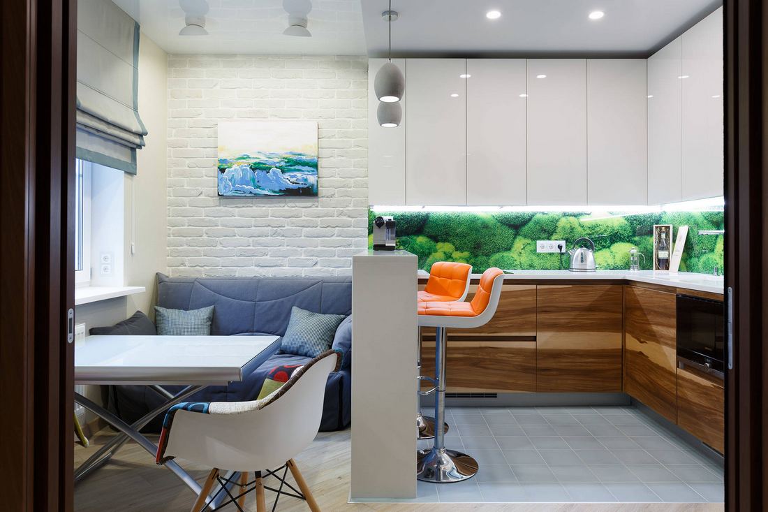 Modern konyha fa és magasfényű fehér felületekkel, étkező kényelmes kis kanapéval, keskeny bárpult