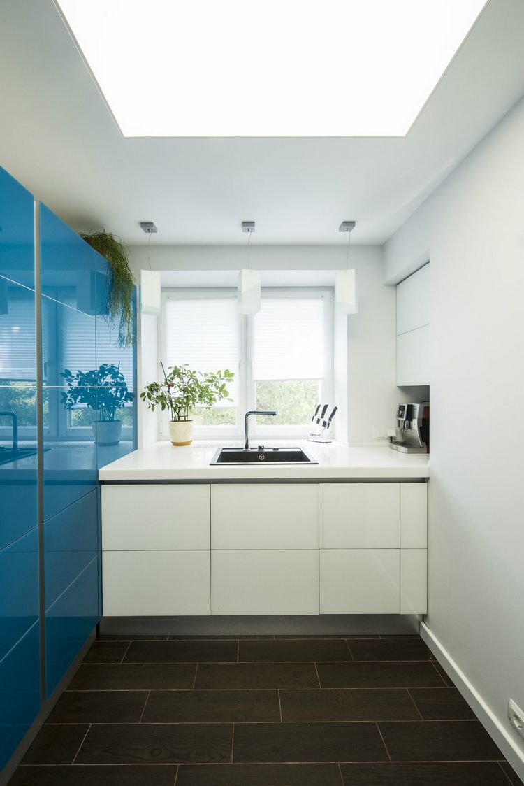Kis konyhában is bátran alkalmazhatunk egy élénkebb kék színt, az alábbi konyha egyik falára épített bútor kapott magasfényű kék felületet.