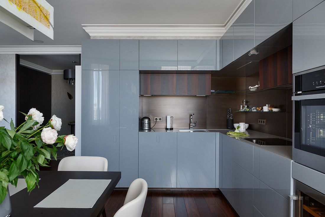 Világoskék konyhabútor magasfényű frontokkal, a padló textúráját és színét ismétlő fa betéttel