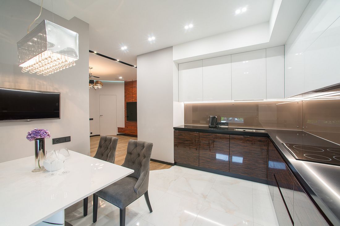 Modern konyha fényes felületekkel, felül fehér, alul fa textúrás szekrényekkel, nagyméretű padlólapokkal, fekete munkalappal