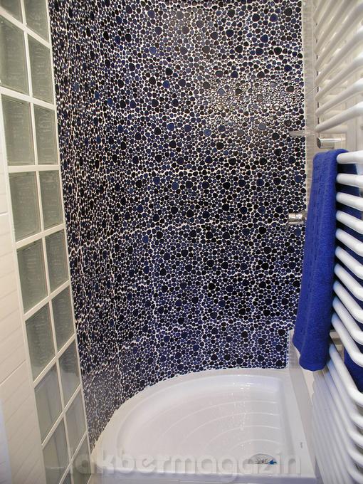 kék kavicsmozaik a zuhanyzó íves falán és üvegtégla