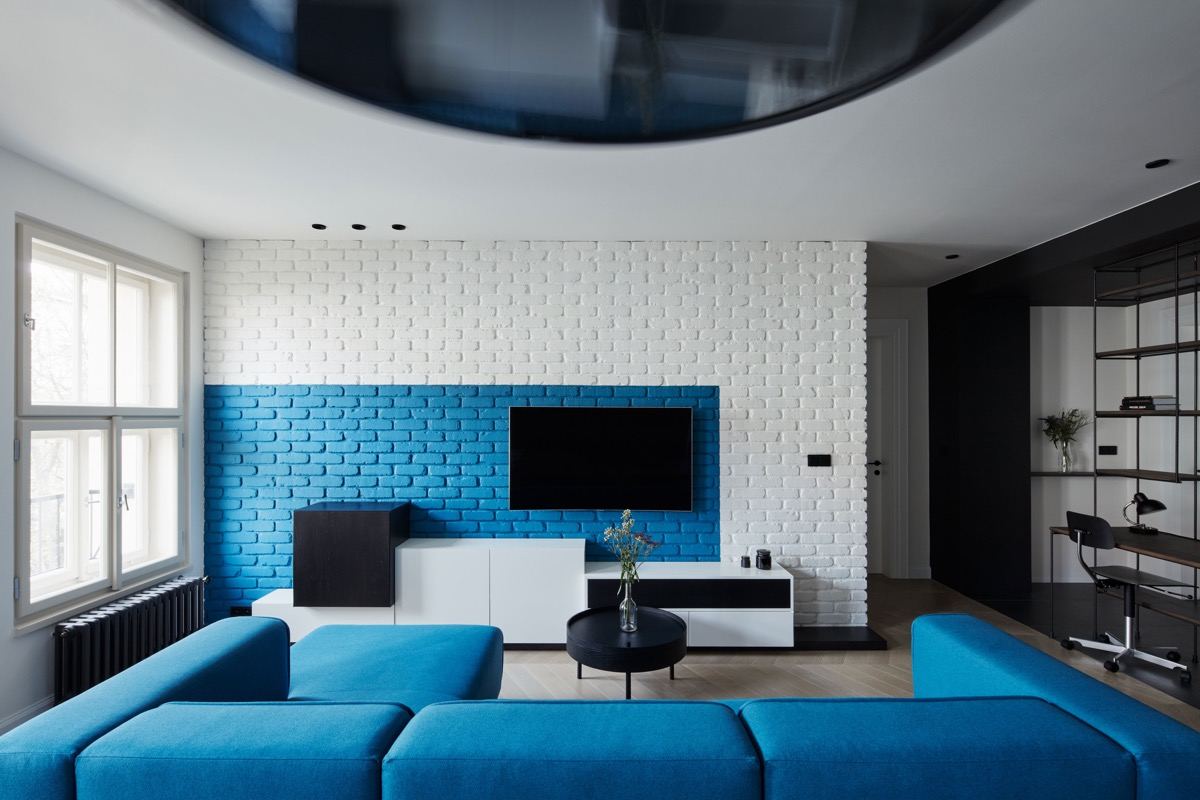 Kék és fehér festés a téglafalon, modern bútor blokk - egyedi háttér a TV falon