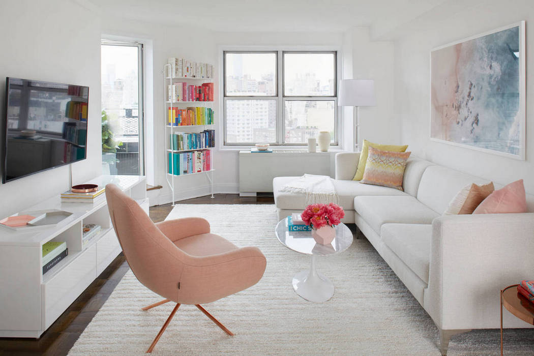 nappali bútorzata egy fehér szőnyeg, fehér kanapék, fehér TV-állvány és dohányzóasztal (más kiegészítők mellett), melyek együttesen egy szellős, egységes teret kölcsönöznek