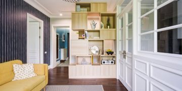Csíkos tapéta, üvegezett és fehérre festett fa térelválasztás konyha és nappali között 51m2-es lakásban, világoskék előszoba falfestés
