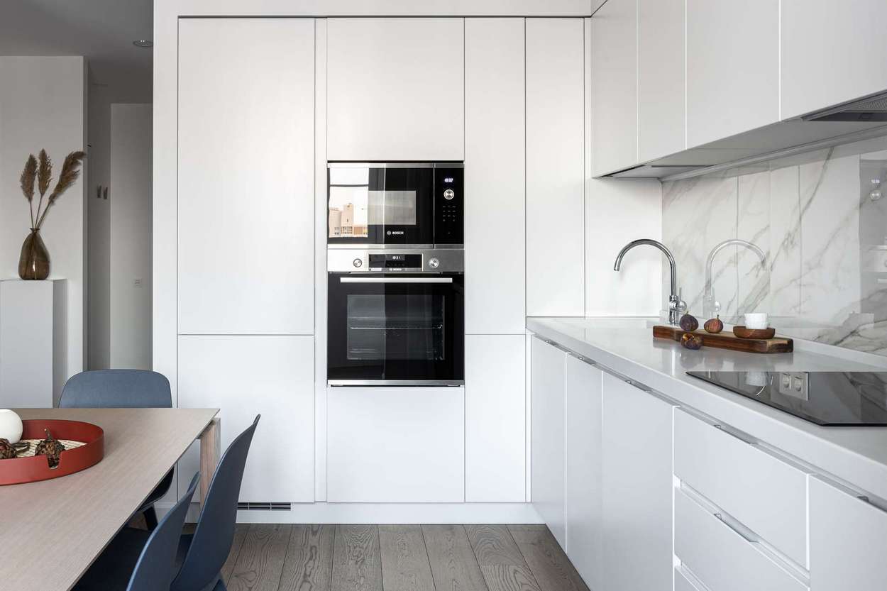 modern konyha - Egyszobás, modern otthon tágas nappali-konyhával, fehér-szürke színpalettával, gardróbszobával