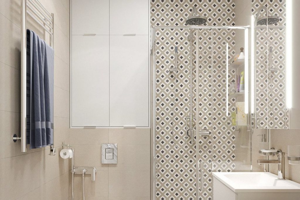 Kis fürdőszoba bézs és mintás csempével, zuhanyfülkével, tárolóhelyekkel