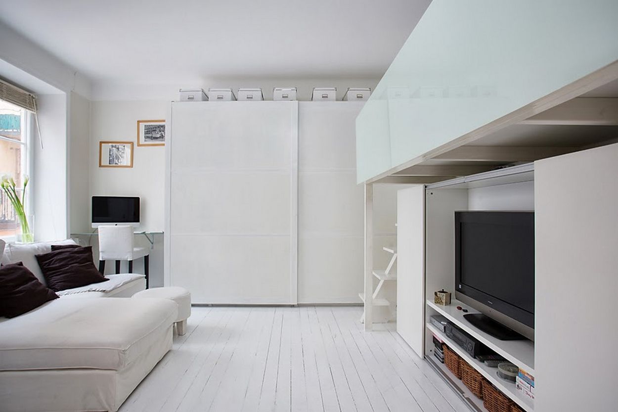 Galéria és TV fal egyben, minimalista stílusban - kis lakás egy szobája fehér dekorációval