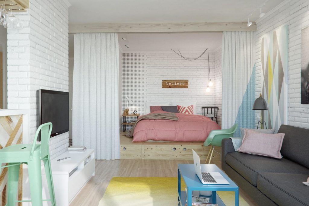 Külön hálószoba kis lakásban függönnyel határolva a zónát, ágy fa pódiumon fiókokkal