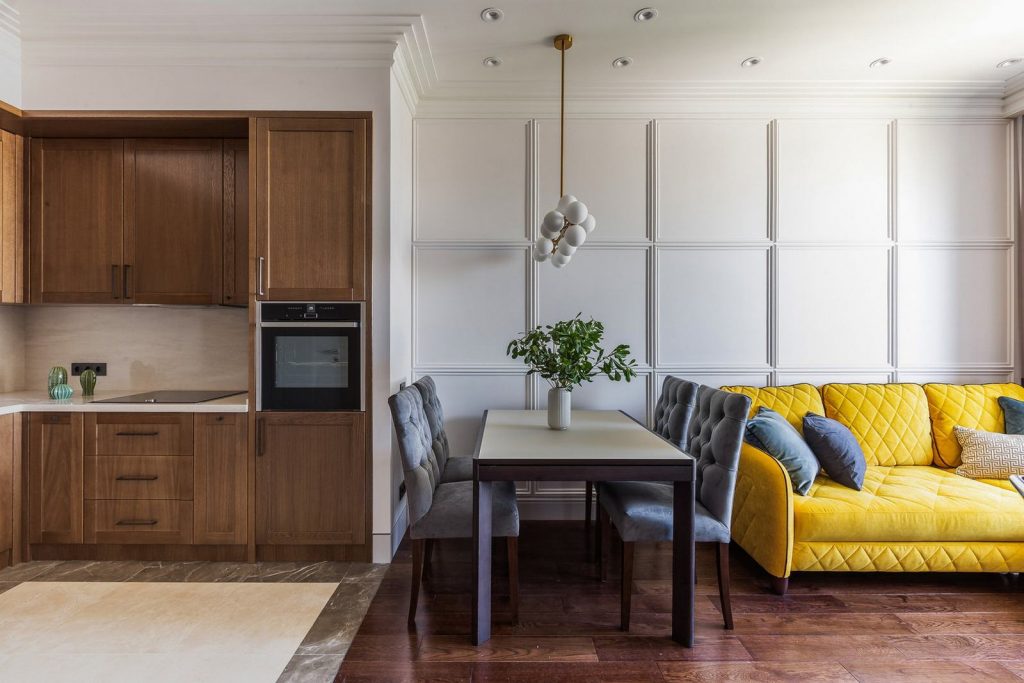 Előszobából konyha a tágasabb terek érdekében, fehér és fa felületek stílusos kombinációja 43m2-es lakásban