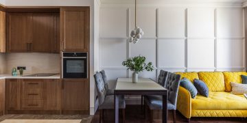 Előszobából konyha a tágasabb terek érdekében, fehér és fa felületek stílusos kombinációja 43m2-es lakásban