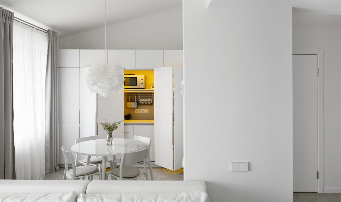 Szekrénynek álcázott konyhabútor hölgy kis lakásában, hófehér berendezés galériával