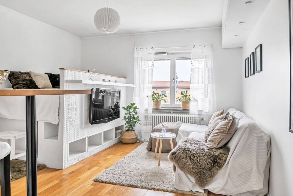 Ügyes helykihasználás kis lakásban, ágy, TV fal és tárolóhelyek egy bútorban kialakítva