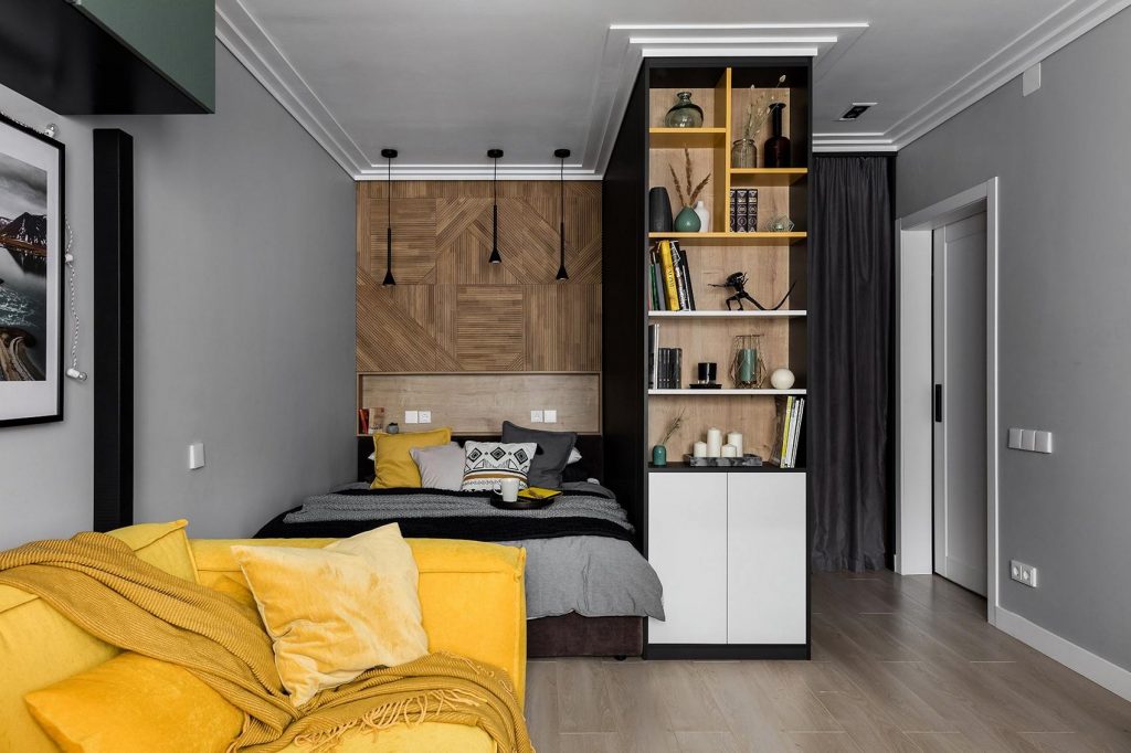 Látványos, férfias egyszobás lakás sárga kanapéval, hálófülkével, szürke-fekete konyhával