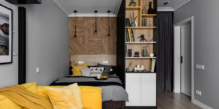 Látványos, férfias egyszobás lakás sárga kanapéval, hálófülkével, szürke-fekete konyhával