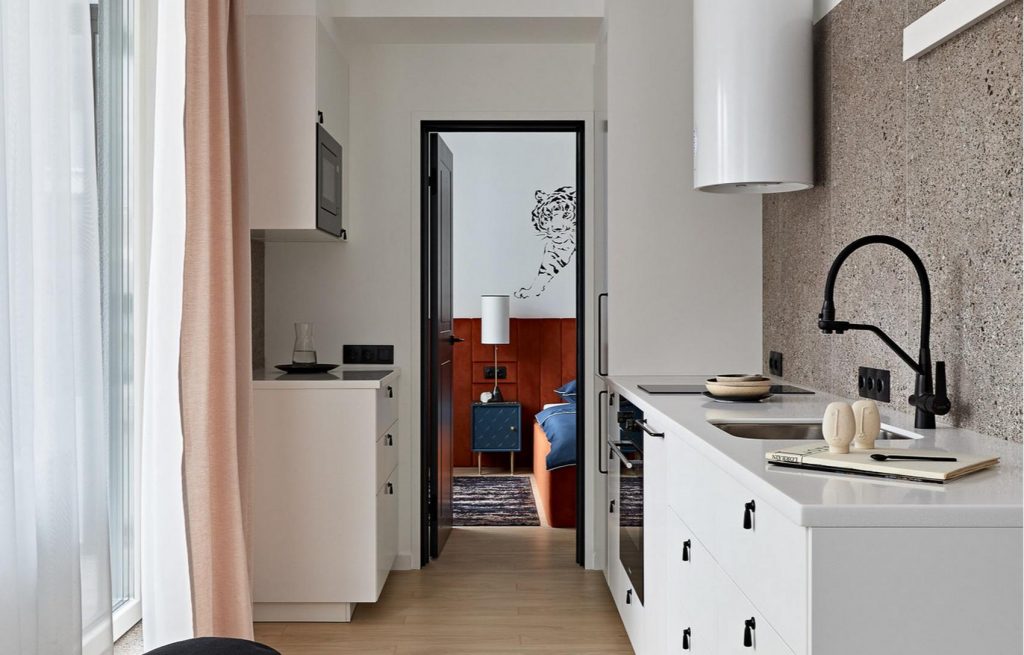 Átjárható konyha, körbejárható elosztás 55m2-es lakásban, világos falak festett trópusi témával