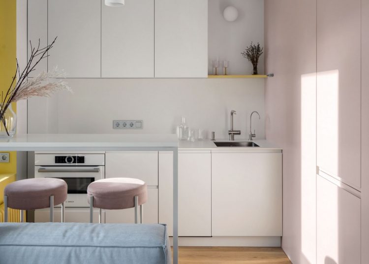 Fiatal lány letisztultan berendezett otthona 32m2-en, tiszta fehérrel, lágy pink, kék és sárga részletekkel