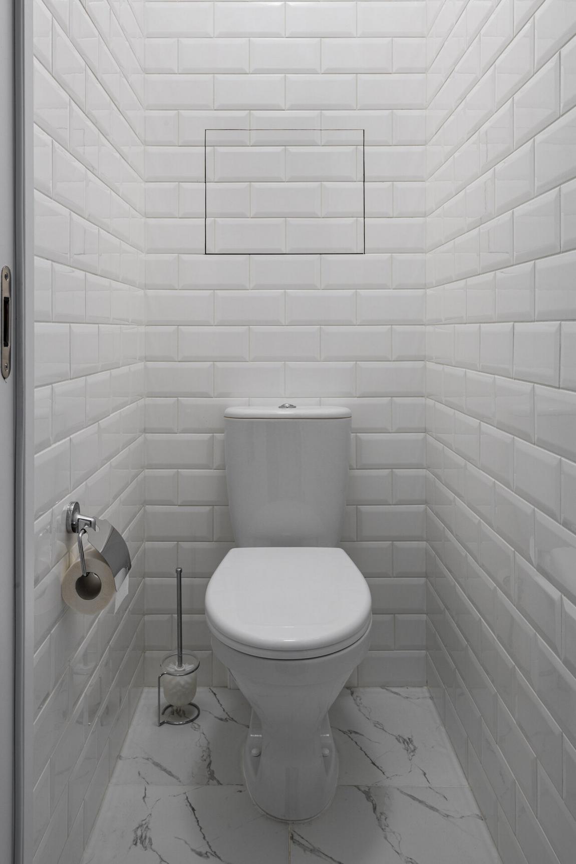 Aprócska fürdőszoba egyszerű, fehér berendezéssel és dekorációval