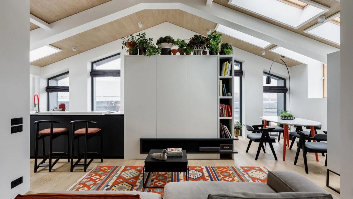 Tetőtéri lakás 18 ablakkal, sok fehér és fa felülettel, modern fekete kiegészítőkkel