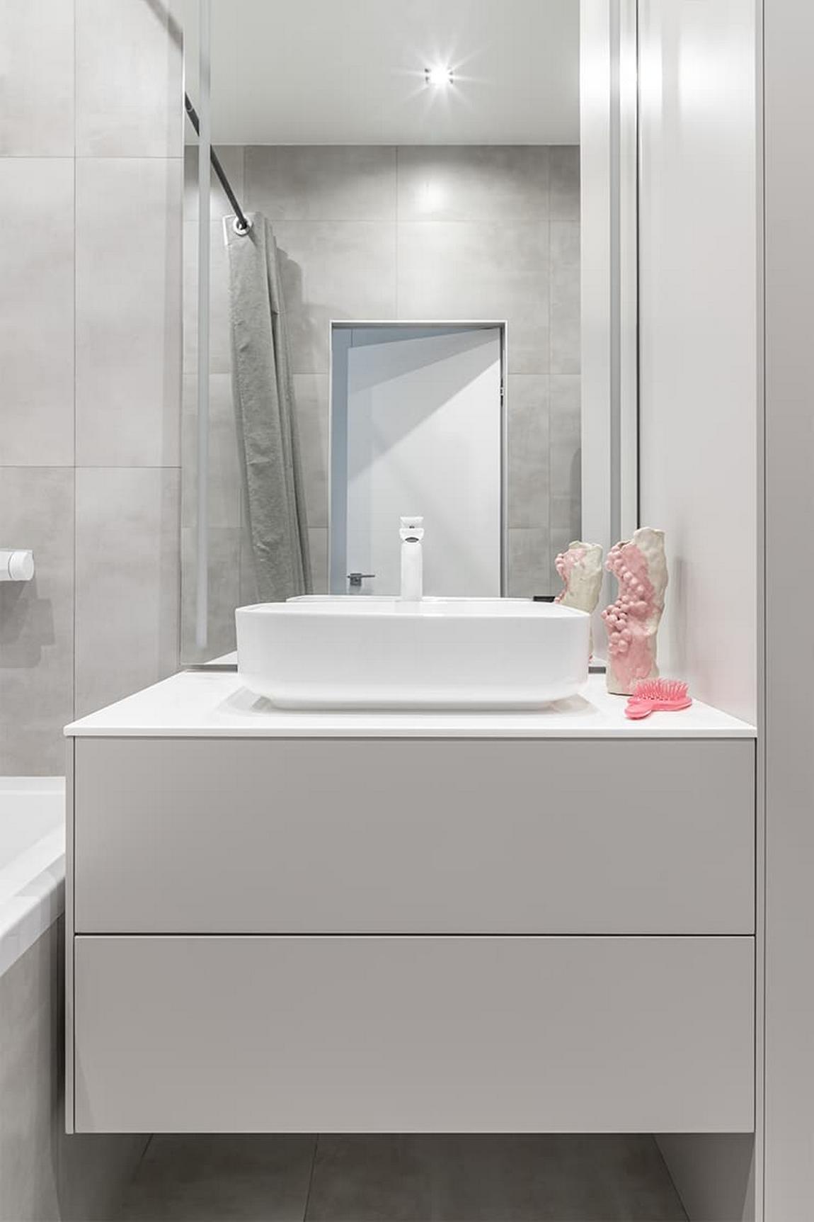 Világos, letisztult, monokróm kis lakás, nagy tükrök, tágas tér