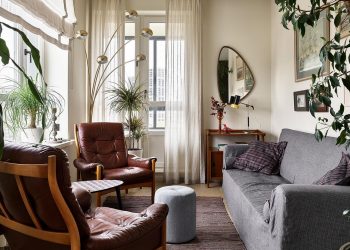 Fiatal férfi otthonos lakása retro hangulattal és sok zöld növénnyel