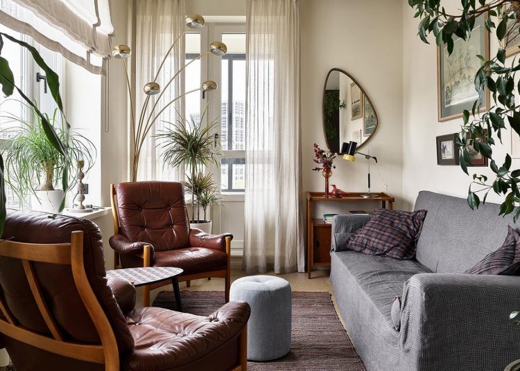 Fiatal férfi otthonos lakása retro hangulattal és sok zöld növénnyel