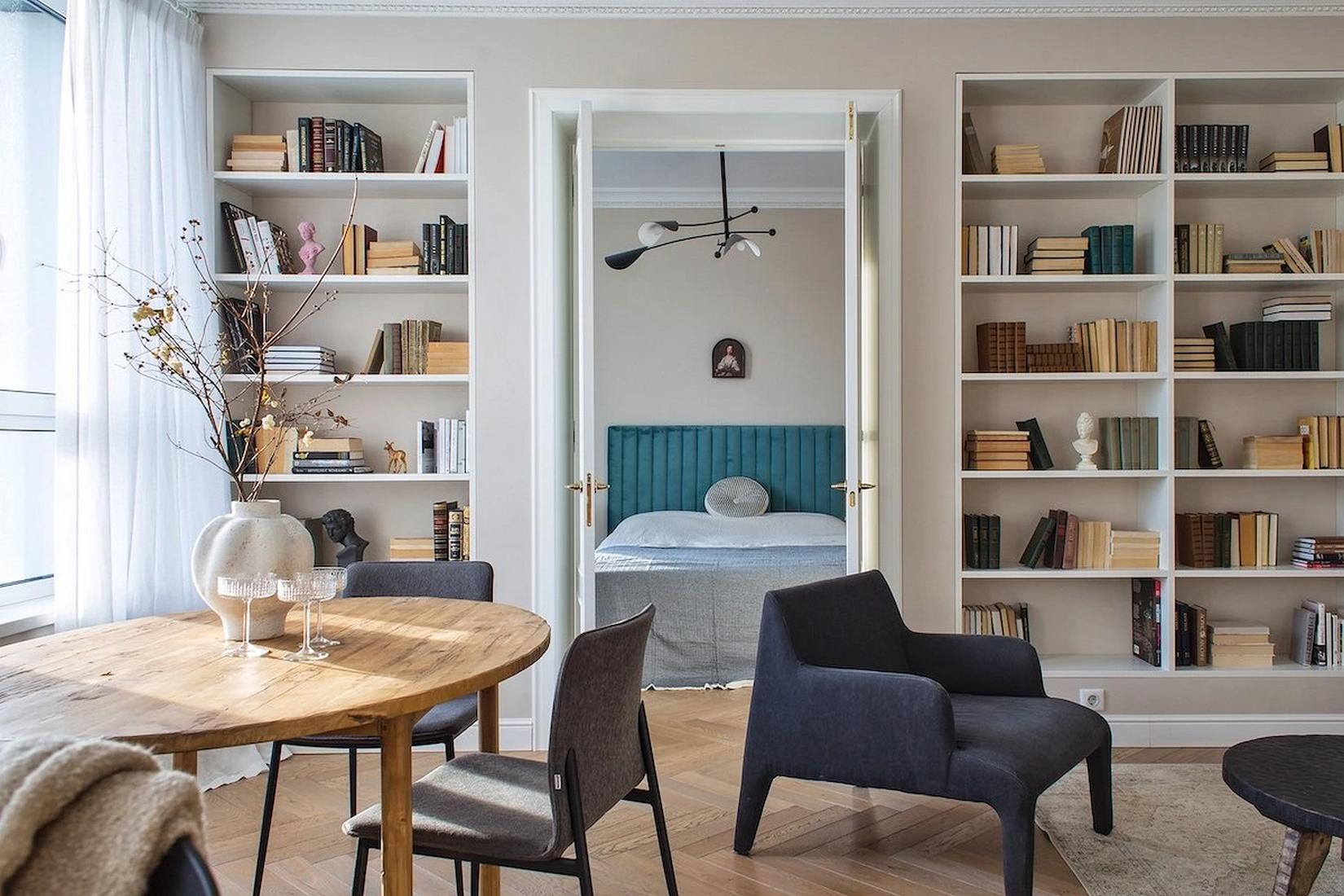 Könyvespolcok egy teljes falon, lágy bézs festés fiatal nő otthonában Könyvespolcok egy teljes falon, lágy bézs festés fiatal nő otthonában