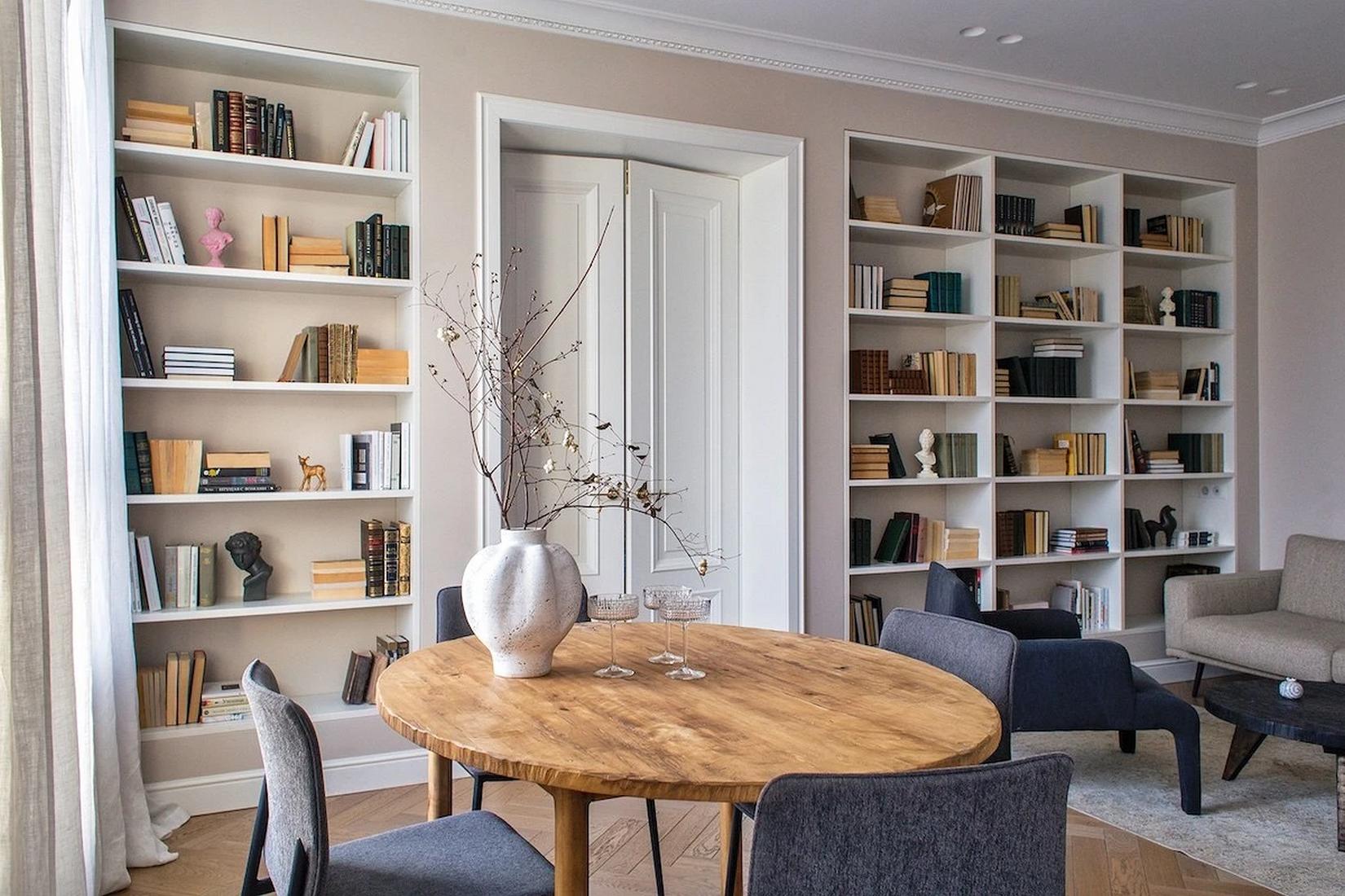 Könyvespolcok egy teljes falon, lágy bézs festés fiatal nő otthonában Könyvespolcok egy teljes falon, lágy bézs festés fiatal nő otthonában