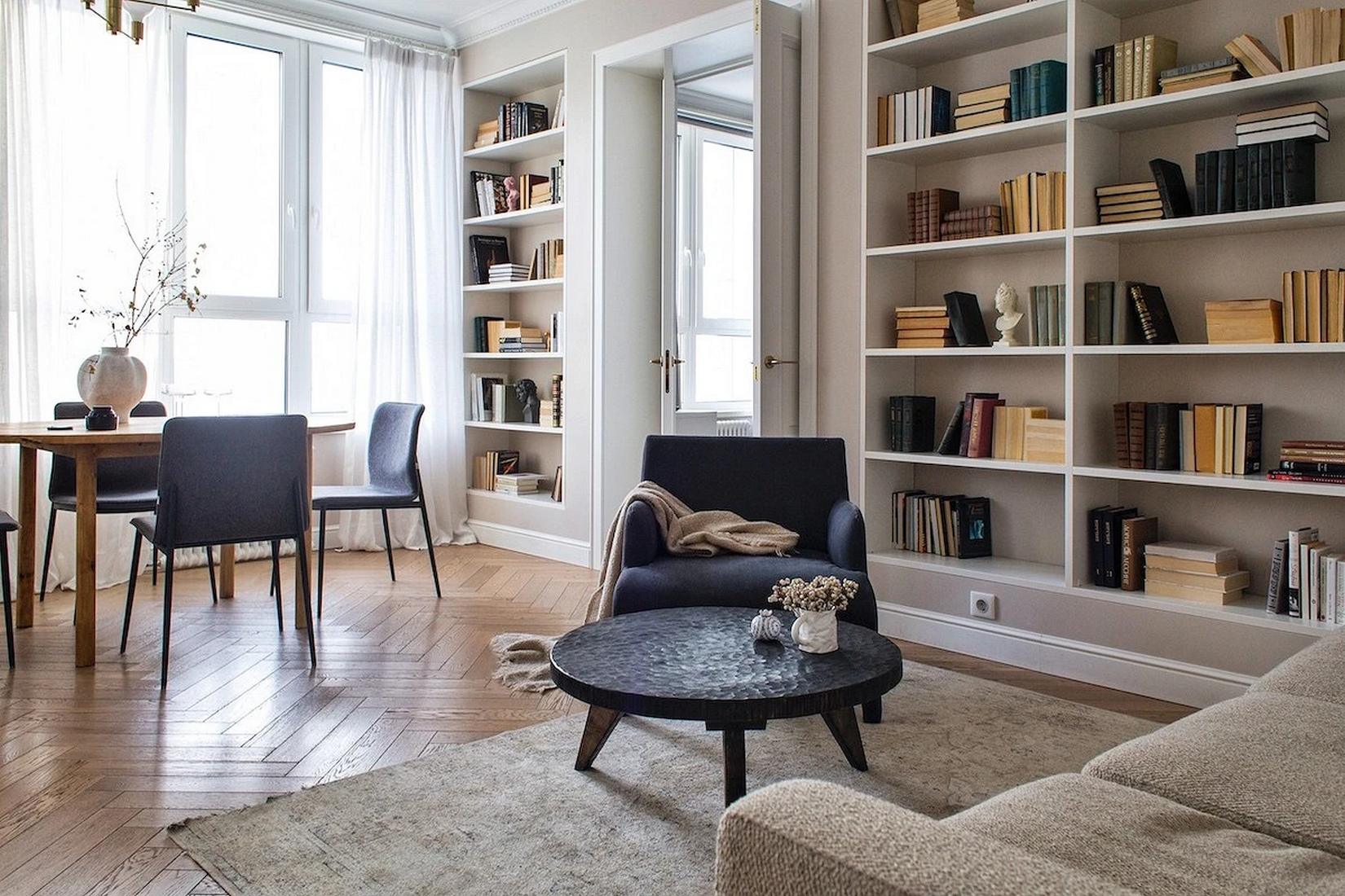 Könyvespolcok egy teljes falon, lágy bézs festés fiatal nő otthonában Könyvespolcok egy teljes falon, lágy bézs festés fiatal nő otthonában