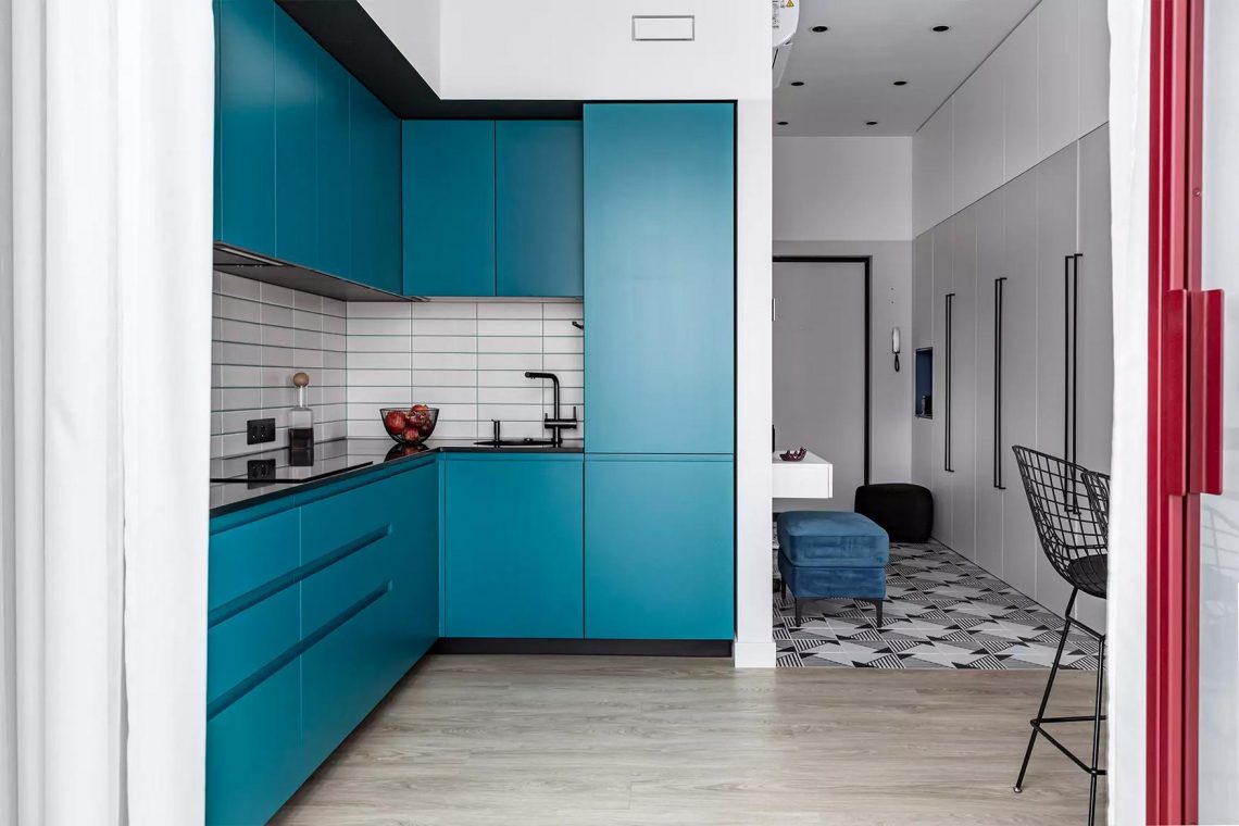 Tetőtéri kislakás modern berendezése: smaragdzöld konyha és borvörös részletek