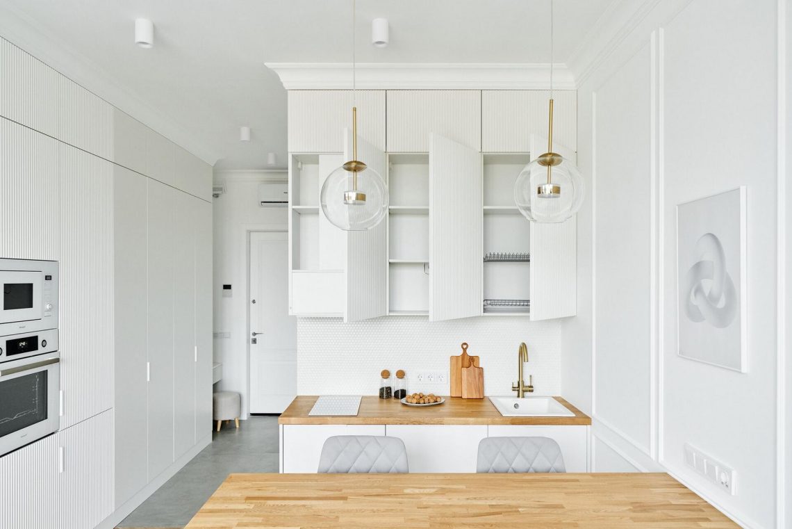 Elegáns hófehér és fa színvilág, díszlécek kis lakásban