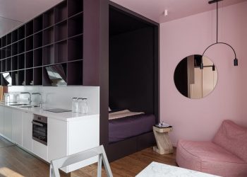 Kreatív fiatal lány kis lakása szekrénybe rejtett dolgozósarokkal