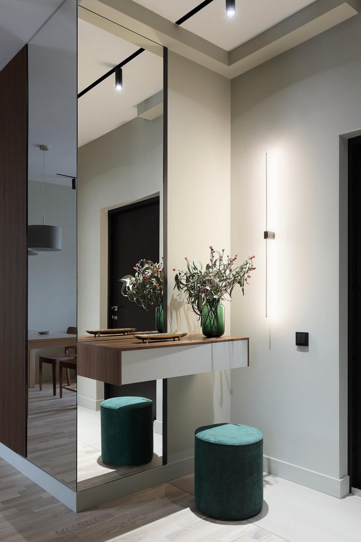 Fenyőzöld, fa, szürke és tükrök: tágasra hangolt 44 m²‑es lakás természetes színvilággal