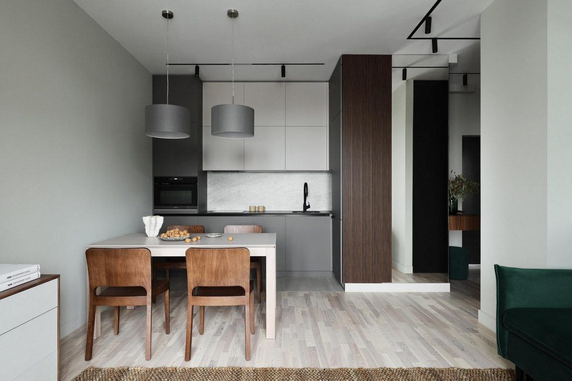 Fenyőzöld, fa, szürke és tükrök: tágasra hangolt 44 m²‑es lakás természetes színvilággal