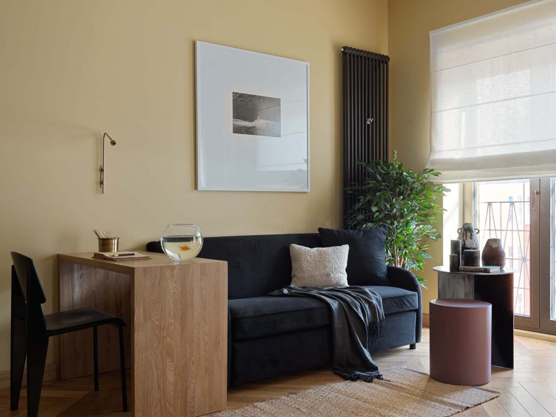 Szép falszín: meleg okker háttér antracit konyhával, kinfolk stílus 40 m2-en