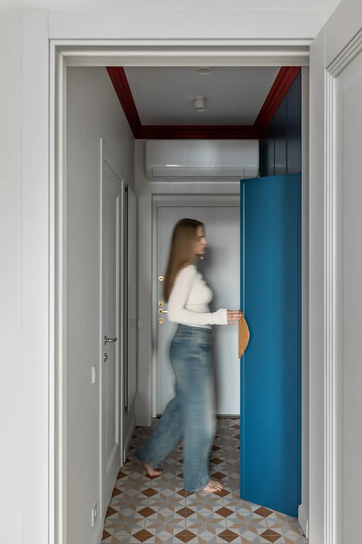 Kristálycsillár, piros mennyezeti díszlécek és kézműves tapéta 40 m2-es lakásban