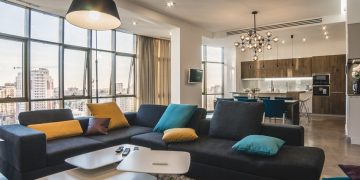 Anyagok és színek remek összhangja egy tágas, elegáns, kényelmes minimál nappali-konyha térben