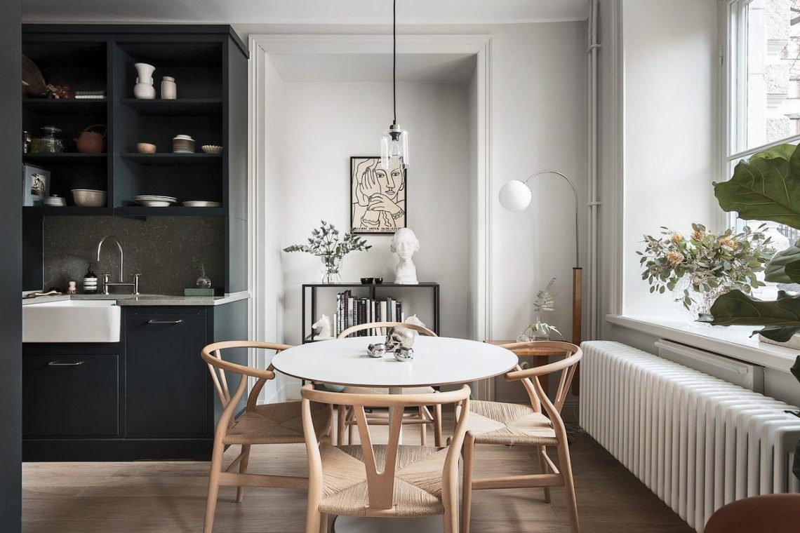 Pici 30m2-es lakás elegáns berendezéssel, világosszürke falakkal, fekete konyhával