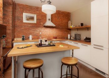 Régi épület, vastag téglafalak - házaspár 40m2-es, egyszobás lakása - háló zóna polcos térelválasztó mögött, természetes színek és anyagok